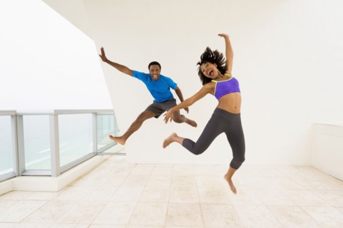 Couple jumping for joy on balcony