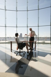 Business people working in large office with glass wall