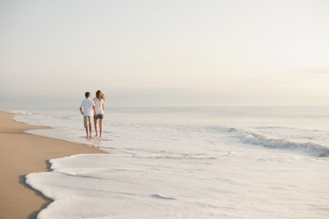 Caucasian brother and sister walking on beach