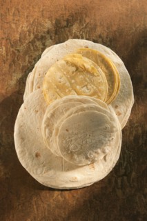 Flour and corn tortillas on table