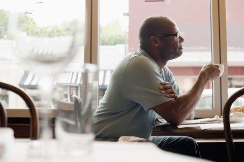 African American man drinking coffee in restaurant