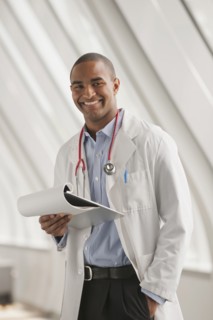 Smiling Black doctor standing with hands in pockets