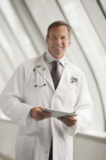 Caucasian doctor using digital tablet in hospital corridor