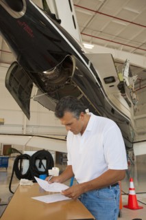 Hispanic man working in airplane hangar