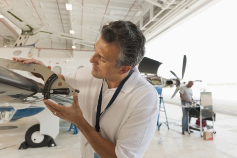 Hispanic man working in airplane hangar