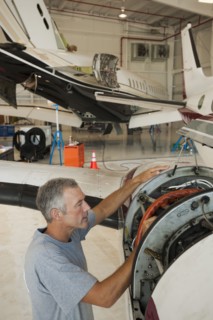 Caucasian man working in airplane hangar