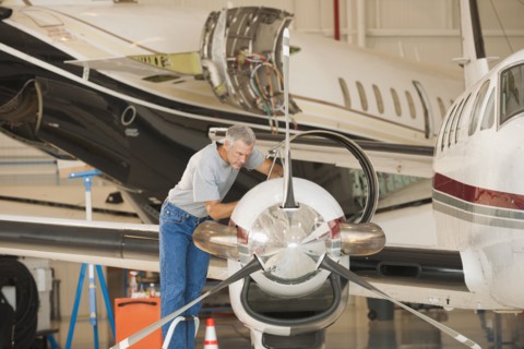 Caucasian man working in airplane hangar