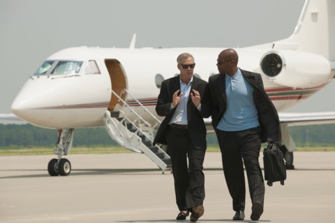 Businessmen walking on airport tarmac