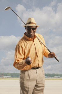 African American golfer with club and ball on tarmac