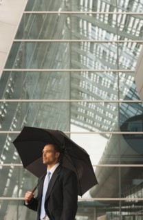 Caucasian businessman underneath umbrella