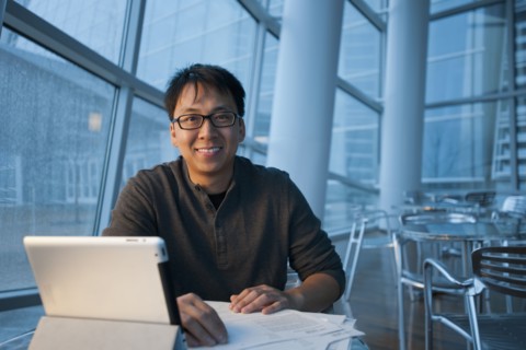 Asian businessman working with digital tablet in cafe