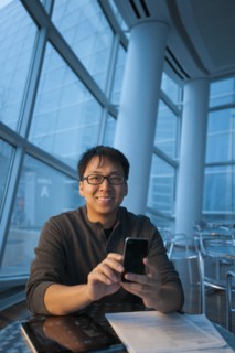 Asian businessman text messaging on cell phone