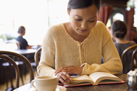 Filipino woman reading book in cafe