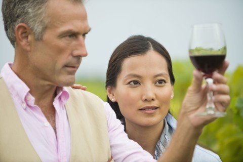 Couple tasting wine together in vineyard
