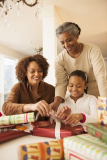 Three generations of women wrapping Christmas presents
