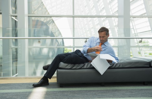 Caucasian businessman reading in lobby area