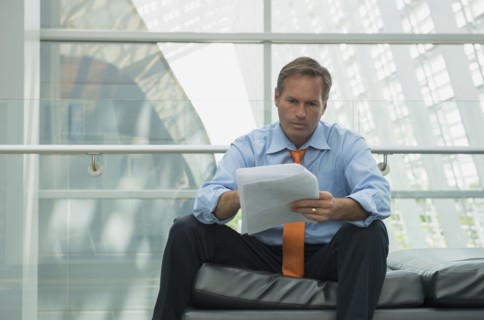 Caucasian businessman reading in lobby area