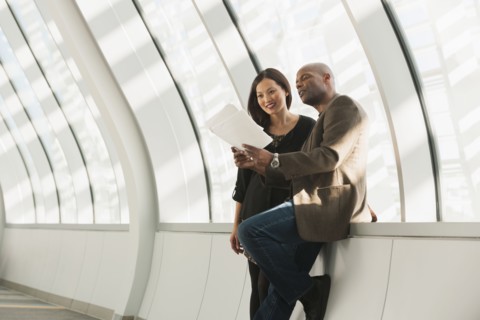 Business people reading paperwork in lobby