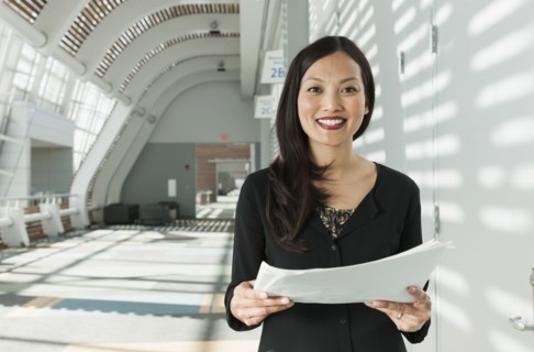 Japanese businesswoman holding papers in office