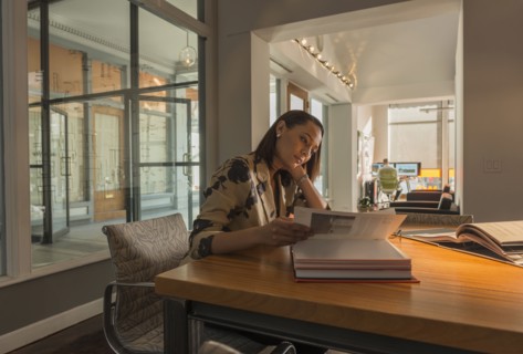 Mixed race businesswoman reading at desk