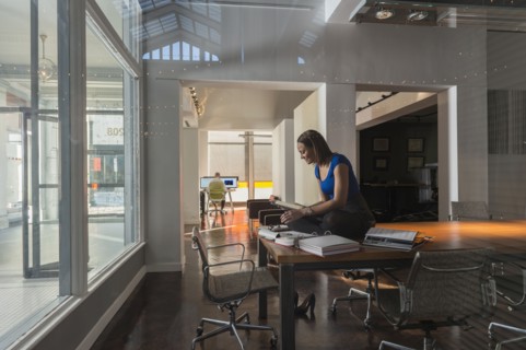 Mixed race businesswoman sitting on conference table