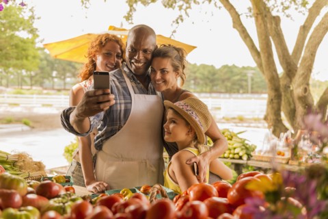 Family taking cell phone selfie at farmers market