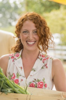 Caucasian woman carrying crate of produce