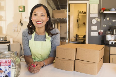 Asian baker smiling in bakery