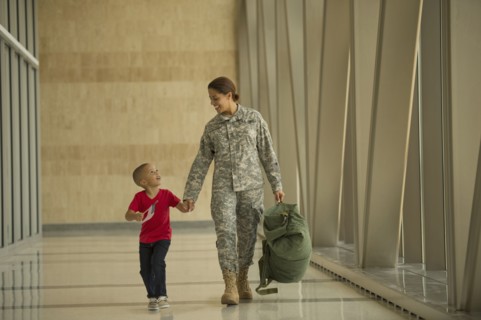 African American soldier and son walking in airport
