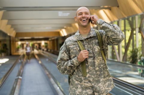 Caucasian soldier talking on cell phone in airport