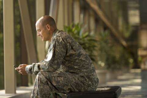 Caucasian soldier using cell phone in airport