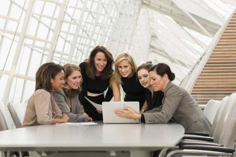 Busy businesswomen using laptop in meeting