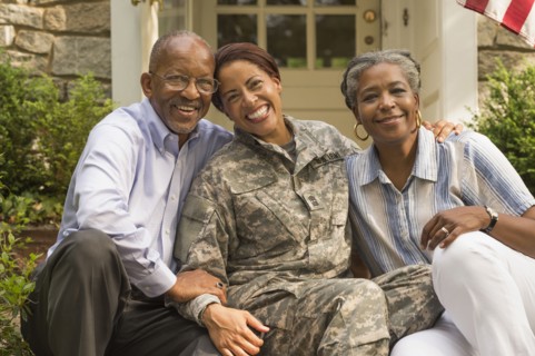 Portrait of soldier sitting on front stoop with parents