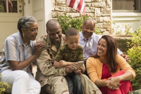 Soldier and multi-generation family looking down at cell phone