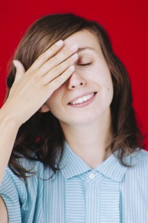 Caucasian woman covering her face