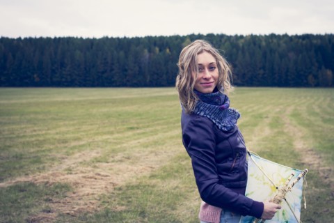 Woman holding kite in field
