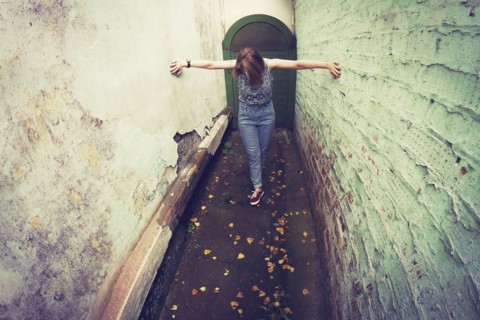 Woman touching walls in alley