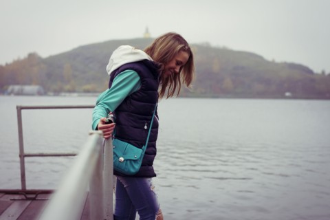 Caucasian woman standing on dock over still lake
