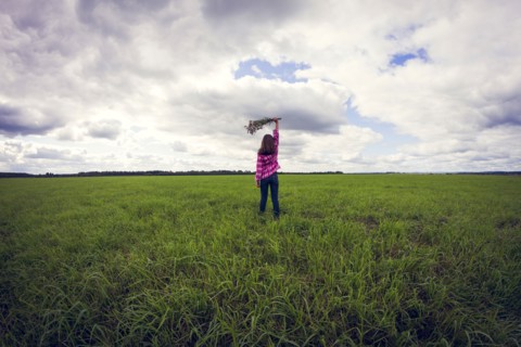 Caucasian girl playing in grassy field