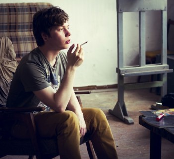 Caucasian man smoking cigarette in living room