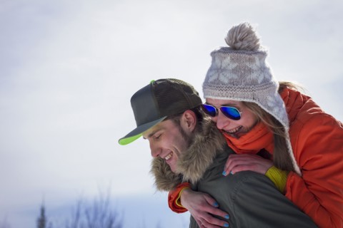 Caucasian man carrying girlfriend piggyback