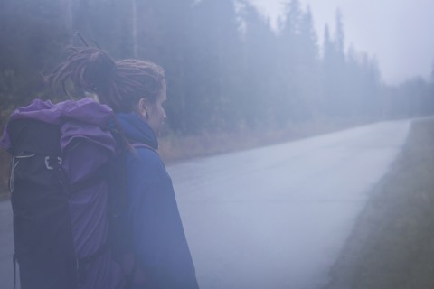 Caucasian hiker walking on remote road