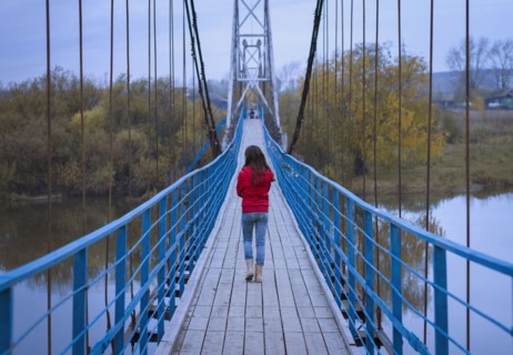 Caucasian girl walking on bridge
