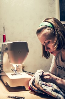 Caucasian woman using sewing machine