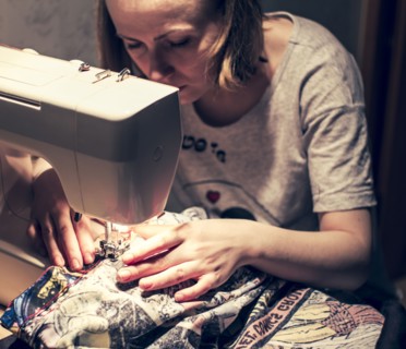 Caucasian woman using sewing machine