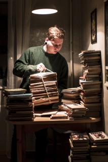 Caucasian man holding stack of books