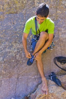 Hispanic man preparing for rock climbing