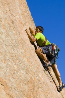 Hispanic man rock climbing
