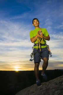 Hispanic man preparing for rock climbing