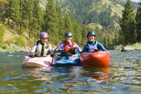 Caucasian girls kayaking in river